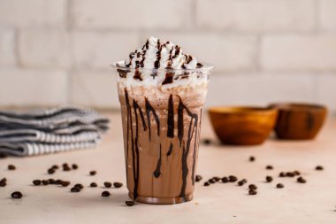 Mocha kremalı dondurma ve çikolata parçacıklı kahve çekirdekleri ve bardakta servis edilen kahve çekirdekleri. Kahveli tatlı Frappuccino karışımı.