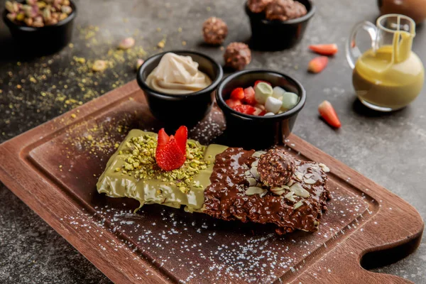 Çilekli ve çikolatalı Pistachio ya da Ferrero Waffle. Kafe Waffle 'ın yemek tatlısı masasının üstünde.