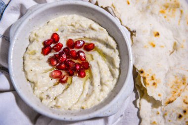 Mutabal nar tohumları, zeytinyağı ve pita ekmeği. Yemek masasında servis ediliyor. Orta doğu baharatlarının üst görüntüsü.