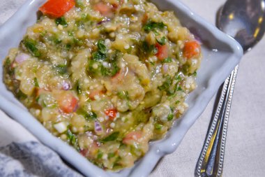 Baba ghanouj, patates püresi, domates ve soğan ile servis edilir.