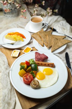Sebze salatalı İngiliz kahvaltısı, domates, patates, marul yaprağı ve çay, kahve ve tatlı kavun ile birlikte sağlıklı kahvaltı masasında servis edilir.