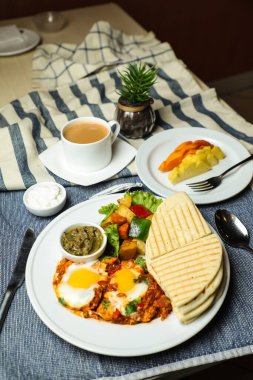 Sebze salatalı Shakshouka: Domates, patates, marul yaprağı ve çay, kahve ve tatlı kavun.