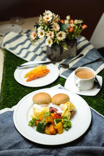 本尼迪克特蛋卷加蔬菜沙拉包括西红柿 莴苣叶和胡萝卜加茶 咖啡和甜瓜 放在饭桌上可以看到健康的英式早餐 — 图库照片