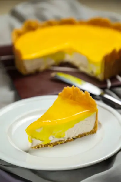 新鲜的柠檬芝士蛋糕片 用叉子和刀片放在餐巾纸上隔离的盘子里烘焙食物 — 图库照片