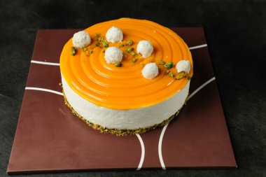 Fıstık çatallı mangolu yoğurt keki ve peçete kenarındaki kafede servis edilen çiçekler yemek pişirir.