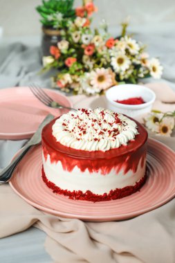 Kırmızı kadife kek, krema, çatallı şeker, bıçak ve çiçeklerle servis edilen tabakta servis edilen ve peçete tarafından izole edilmiş kafe yemekleri içerir.