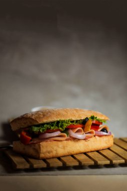 Ciabatta Füme Jambonlu Sandviç ahşap üzerine izole edilmiş mayonez sosu ve patates kızartması kovası ile gri arka planda İtalyan fast food manzarası