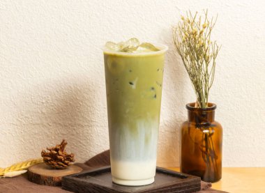 Tek kullanımlık bardakta servis edilen buzlu Kyoto matcha latte çayı tahtadan yapılmış Tayvan buzlu içeceği manzarası.