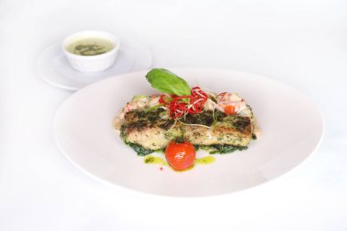 HERB ÇIĞLIKLARI HAMour FİLTİSİ, masadaki Arap yemeklerinin üst görünümünde servis edilen sosla servis edilir.