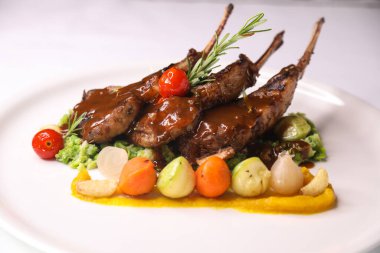 NEWZELAND LAMB CHOPS veya domates, soğan ve patatesli koyun CHOP Masa başındaki Arap yemeklerine yakın bir görünümde servis edilir