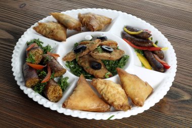 Sıcak aperatifleri çıtır tavuk, samosa ve ızgara mumya sosisiyle karıştırın. Masa başı yemek masasında servis edilir.