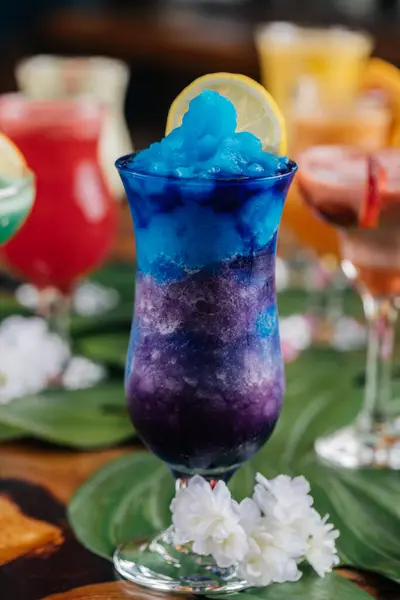 Blue Hawaiian lagoon ice drink with lime slice served in glass isolated on table side view of healthy morning arabic drink