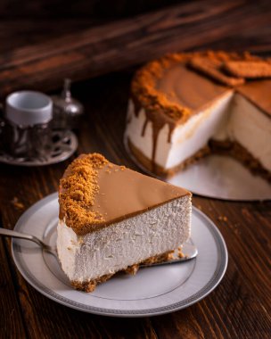 Çikolatalı cheesecake dilimi, ahşap masa kenarında servis edilir. Arap kafe tatlı, yemek pişirilir.