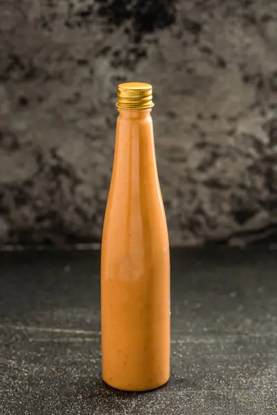 Spicy sauce Bottle isolated on dark grey background side view of fast food