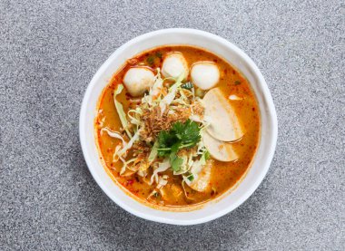 Tayland usulü erişteli laksa çorbası, Tayland sosisi ve Hong Kong yemeklerinin arka planında izole edilmiş balık köftesi.