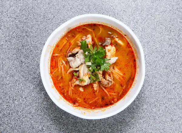 Tayland pilavlı şehriyeli Tom yum tavuk çorbası. Gri arka planda Hong Kong yemeğinin üst görüntüsünde servis ediliyor.