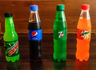 Çeşitli meşrubat pepsi, 7 üstü, Mirinda 245 ml ve çiğ çöpü ahşap arka planda izole edilmiş soğuk içecekler.