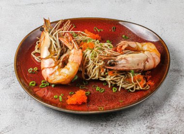 karidesli mantarlı capellini gri arka planda Singapur yemeğinin üst görüntüsünde servis edilir.