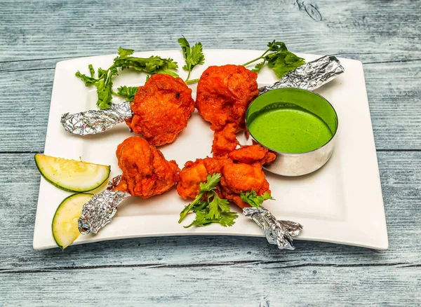 chicken lollipop or lollypop with chutney sauce served in dish isolated on wooden table top view of indian spicy food