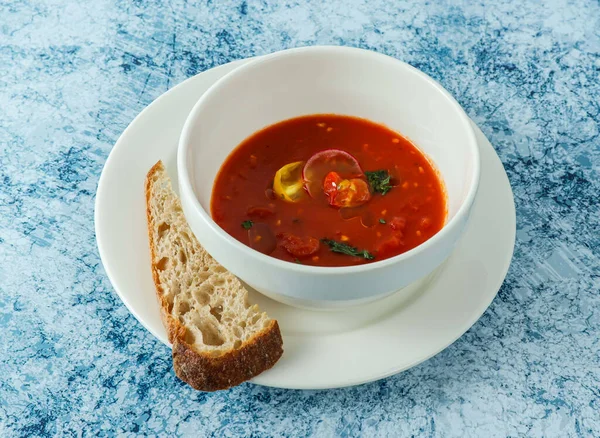 イタリア料理のバックグラウンドトップビューに分離されたプレートにパンを添えたトマトスープ — ストック写真