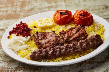 Hint kebablı sığır eti, sığır eti tikka ve mandi biryani pilavı, domates ve soğan.