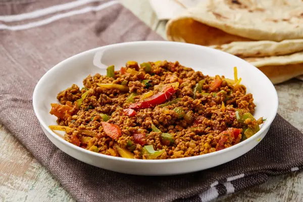 Keema masala, qeema ya da khima domates ve zencefil ile servis edilir.
