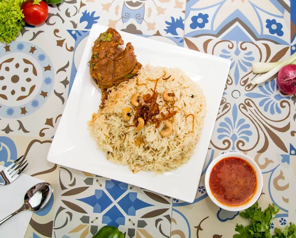 Madfoon Tavuğu biryani pilavı, yemek masasında servis edilir.