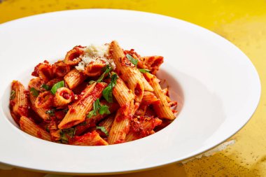 Baharatlı Penne Arrabbiata Makarnası. Domates ve acı biber soslu. Masanın üstünde, Arap usulü fasfood 'un üst görüntüsünde servis ediliyor.