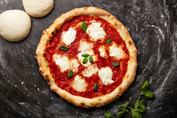 Margherita Pizza with dough isolated on dark background with raw food top view of italian fastfood appetizer