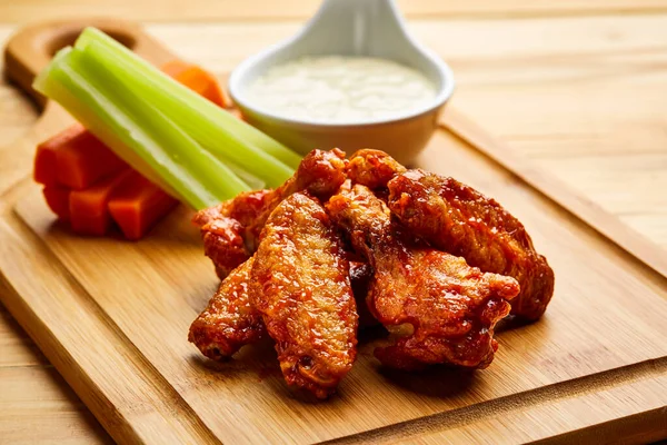 Buffalo Chicken wings with dip served in dish isolated on wooden table top view of starter fastfood appetizer food