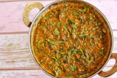 Koyun Palak Gosht Korma, Karahi 'de servis edilmişti. Hint baharatlarının üst katındaki masada tek başına.