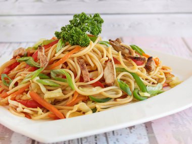 ÇİN ÇİN NOODLES içinde brokoli, havuç, domates ve taze soğan Çin yemeği yakın görünüm masa izole servis edilir