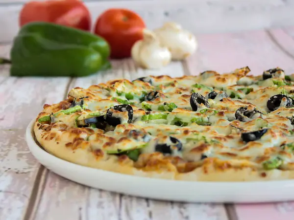 VEGETABLE PIZZA topping with capsicum, mushroom, tomato and olives served in dish isolated on table side view of arabic fastfood