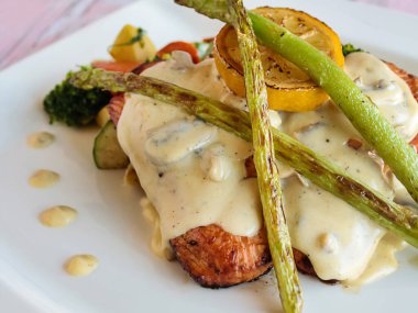 GRILLED SALMON Balığı mayonez soslu ve limon dilimli. Izgara deniz ürünlerinin üst görüntüsünde, izole bir şekilde servis ediliyor.