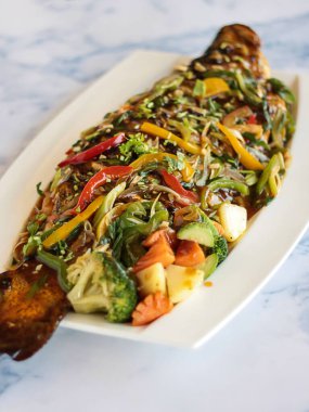 THAI RED RIVER BALIĞI Izgara deniz mahsulleri yakın masa görüntüsü izole tabakta servis edilir