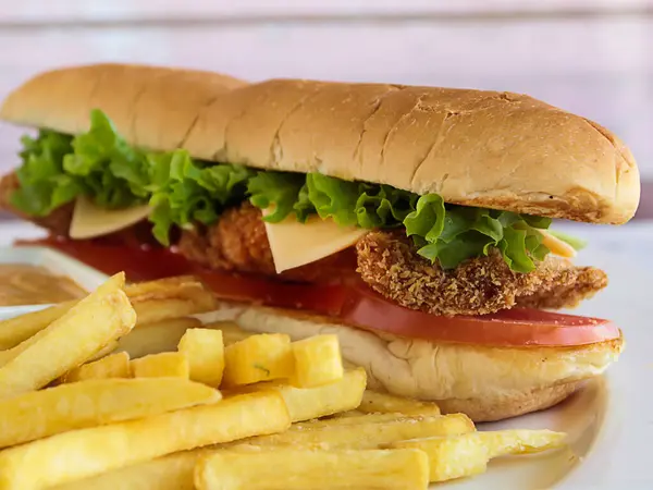 SHRIMP SANDWICH with french fries served in dish isolated on table closeup side view of fastfood