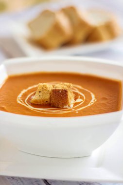 Ekmek ve limon dilimiyle servis edilen TOMATO SOUP sıcak çorba masasının en üst görüntüsünde izole edilmiş.