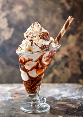 Ferrero Rocher milkshake, dondurma, çikolata ve samanla servis edilen krema. Sağlıklı içkinin koyu arka planında izole edilmiş.