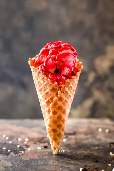 Strawberry gelato with ice cream, chocolate served in cone isolated on dark background closeup side view of cafe baked dessert food