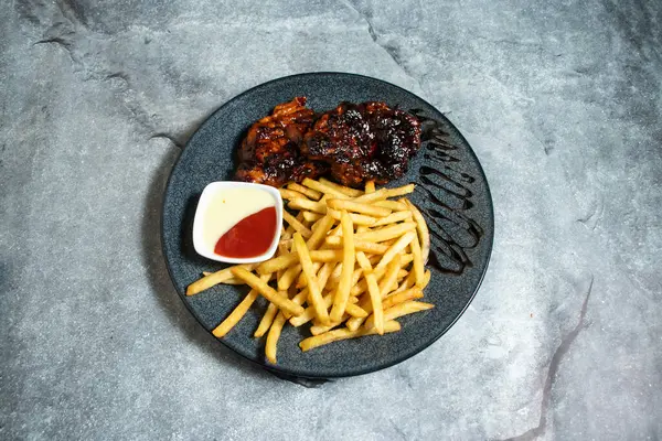 Peri Peri tavuğu ve patates kızartması arka planda izole edilmiş olarak servis edilen Hint usulü fırınlanmış yemek tatlısı.