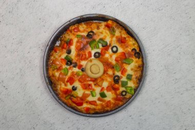 ... zeytinli, domatesli, soğanlı, salatalıklı, mantarlı ve peynirli sebzeli pizza. Gri arka planda, bangladeş fast food 'un üst manzarasında servis ediliyor.