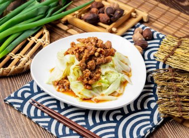 Kızarmış domuz eti, taze soğan ve yemek çubuklarıyla servis edilen beyaz sebzeler, Tayvan yemeğinin peçete tarafından izole edilmiş.