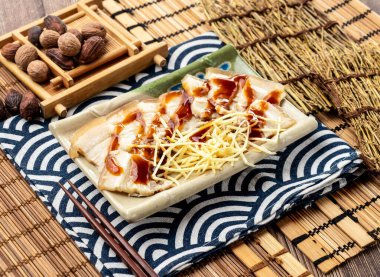 Çin sarımsaklı beyaz et, yemek çubuklarıyla servis edilir. Tayvan yemeğinin peçete tarafından izole edilmiş.