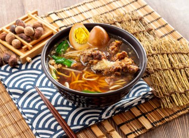 Domuz kaburgalı çıtır erişte çorbası, korunmuş yumurta, yemek çubukları peçete tarafında servis edilen yemek çubukları Tayvan yemeği.