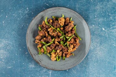 Kızarmış yeşil biberli tavuk. Bahriyeli arka planda izole bir tabakta servis ediliyor. Bangladeş yemeklerinin üst görüntüsü.