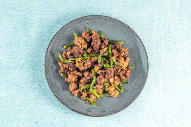 Kızarmış yeşil biberli tavuk. Gökyüzünde izole edilmiş tabakta servis ediliyor. Bangladeş yemeklerinin üst arkaplan görüntüsü.