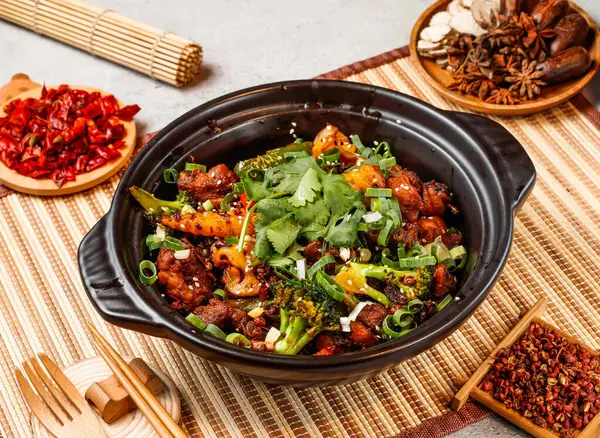 stock image Dry pot spare ribs with red chilli, chopsticks and fork served in pot isolated on background side view of taiwanese food