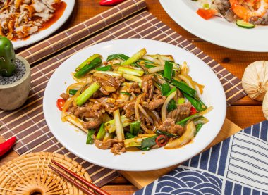 Tayvan yemeklerinde servis edilen yeşil soğanlı, kızarmış erişteyi karıştır.