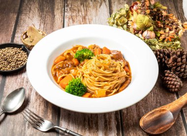 Tayvan faslılarının ahşap masa manzarasında servis edilen havuçlu, brokolili, kaşıklı ve çatallı sığır eti çorbası.