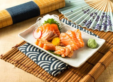 Japon yemeğinin ahşap arka planında peçeteye izole edilmiş salatalı somon balığı.